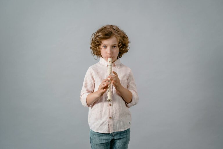 Child playing recorder musical instrument, showcasing a passion for music and learning.